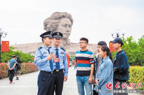 　　在橘子洲头，民警在巡逻过程中与游客交流。 长沙晚报通讯员 彭滔 摄
